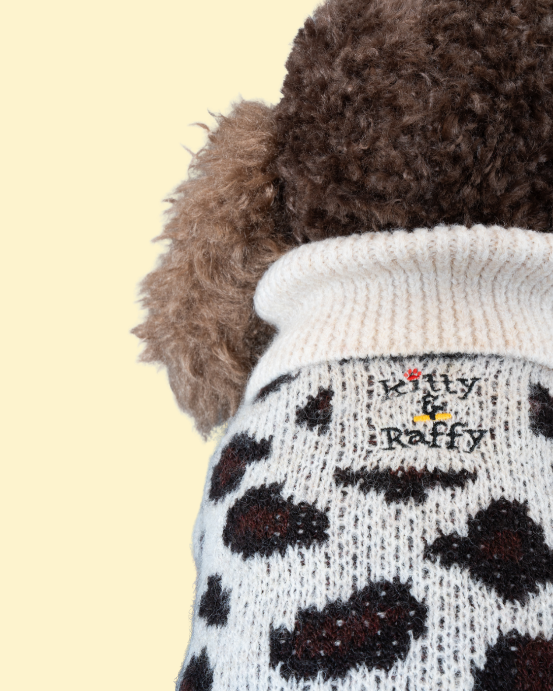 A close up shot of Comfort Me Raffy wearing a leopard print fluffy knit jumper. The image shows a zoomed in view of the jumper's logo 