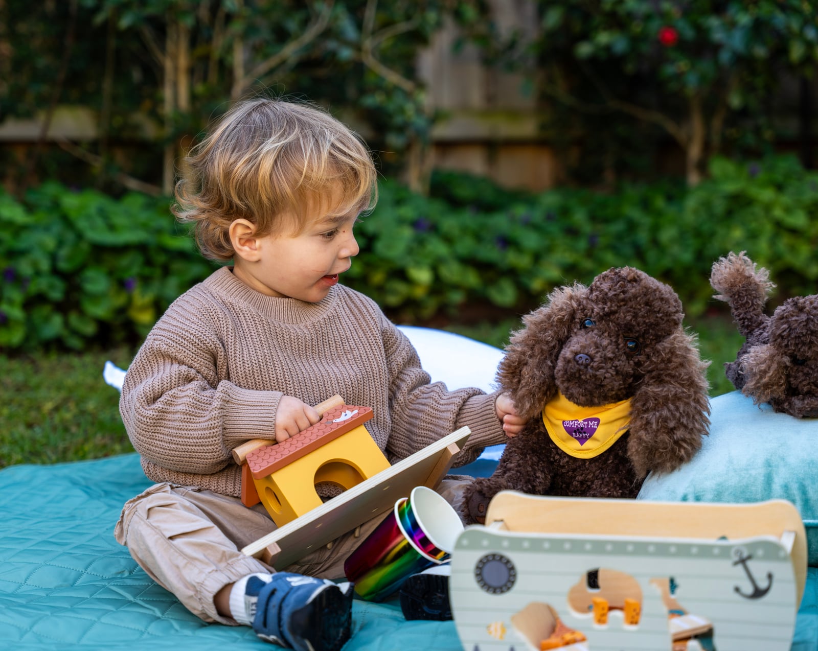 A child playing alongside Comfort Me Raffy