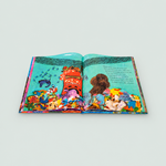 An open illustrated book laid flat on a light gray background, showing a colorful underwater scene with sea creatures, coral, and a dog illustration on the pages.