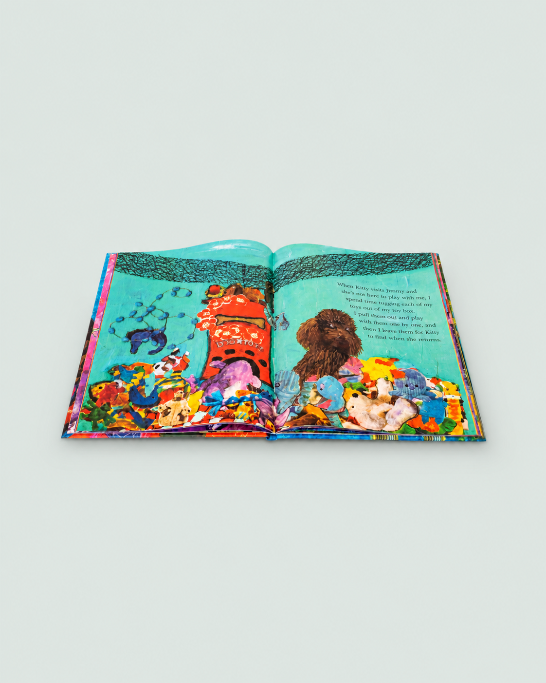 An open illustrated book laid flat on a light gray background, showing a colorful underwater scene with sea creatures, coral, and a dog illustration on the pages.